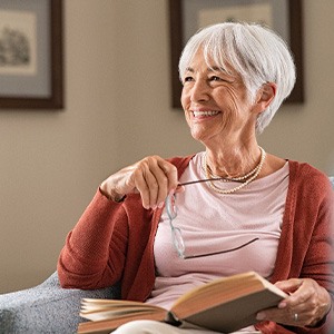 Woman smiling while reading at home