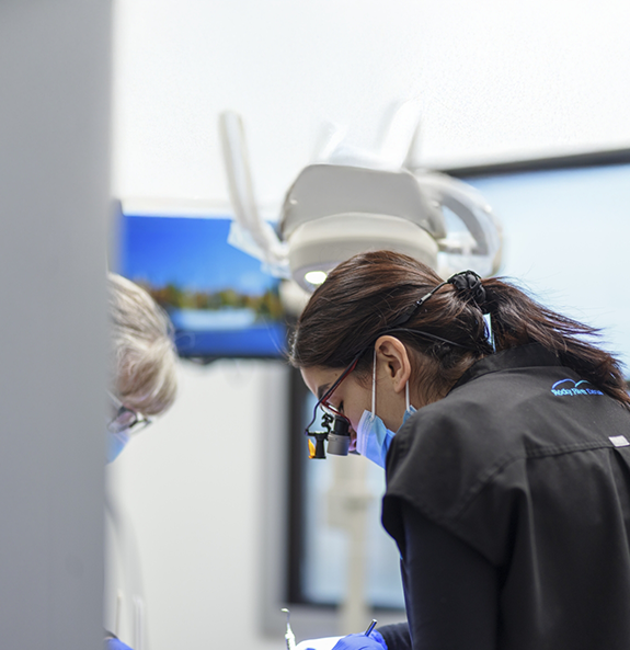 Rocky River dentist and assistant performing a dental procedure on a patient