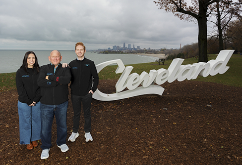 Three dentists standing near a small statue that says Cleveland