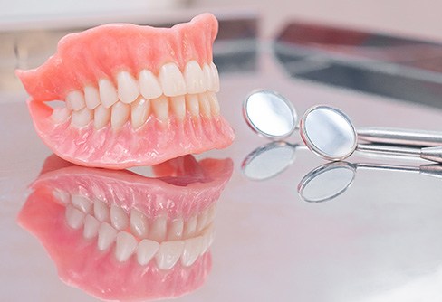Full upper and lower dentures On reflective tabletop