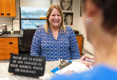 Receptionist smiling at a patient at front desk