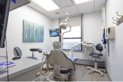 Dental exam room with white walls and a window