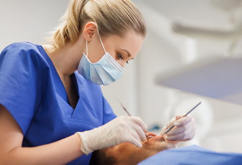 Dentist performing gum disease treatment on a patient