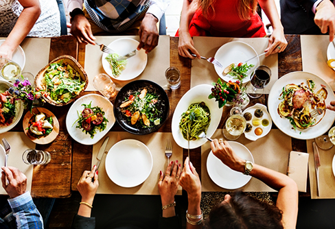 Several people sitting at a table and filling their plates with food