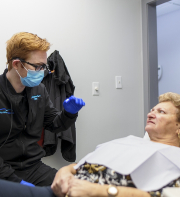 Older woman in the dental chair talking to her dentist