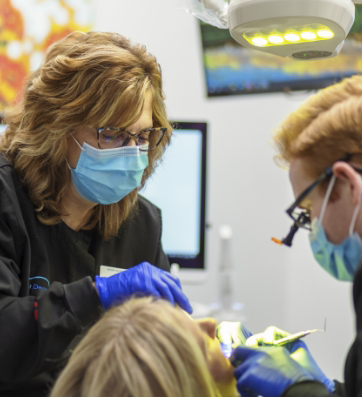 Dentist and assistant performing a dental procedure on a patient