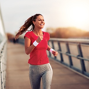 Woman smiling while running on trail