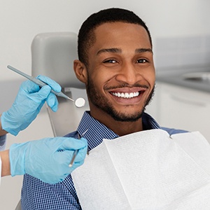 Patient smiling while sitting in dentist chair