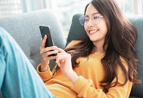 Woman smiling while scrolling on her phone