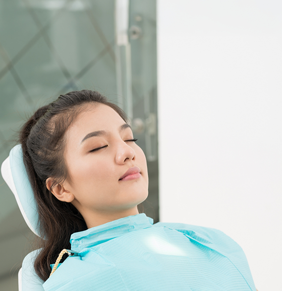 Woman relaxing in dental chair thanks to sedation dentistry in Rocky River