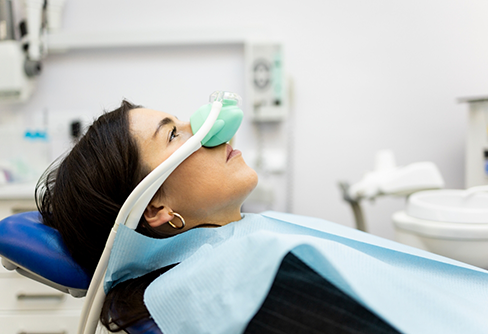 Patient in dental chair with a nitrous oxide mask over their nose
