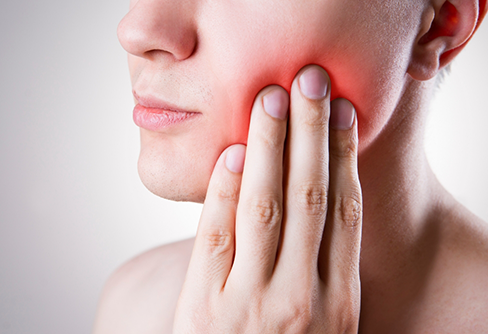 Person holding their cheek in pain