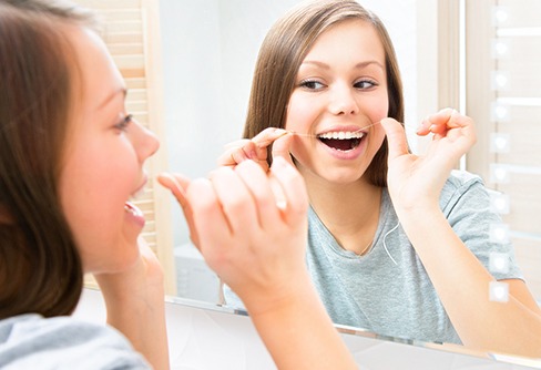 Woman flossing her teeth