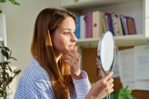 Woman looking at her loose tooth